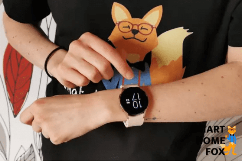 Die Samsung Galaxy Smart Watch wird am Arm getragen und ein Finger zeigt darauf